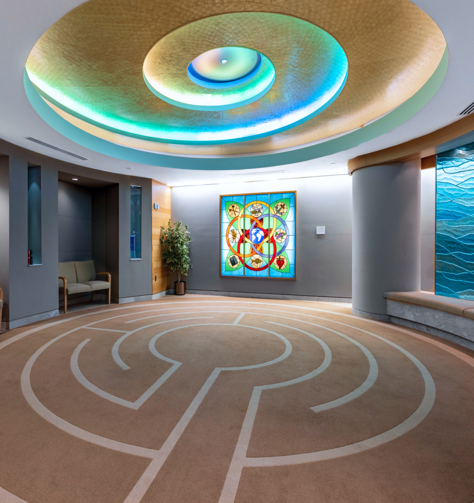 Meditation room with labyrinth floor and stained glass window.